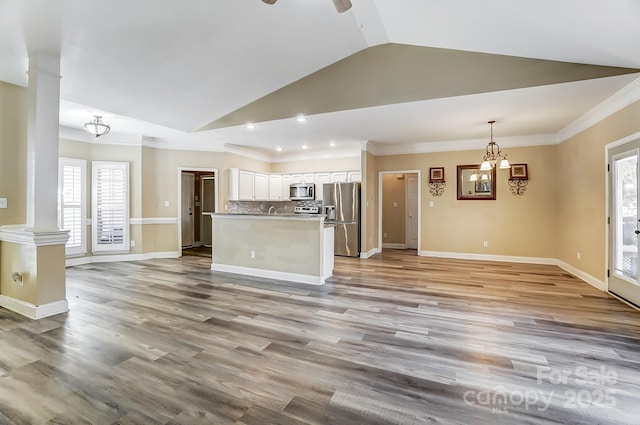 kitchen featuring tasteful backsplash, hanging light fixtures, appliances with stainless steel finishes, a healthy amount of sunlight, and white cabinets