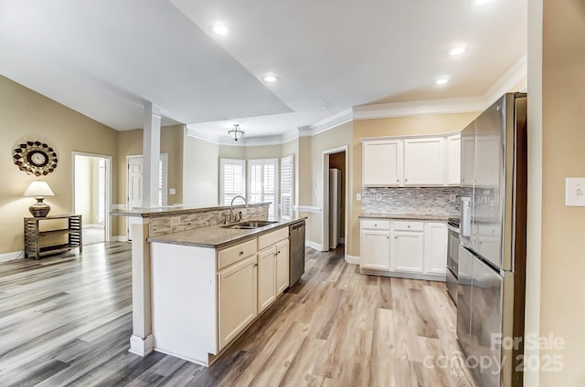 kitchen featuring a kitchen island with sink, sink, white cabinets, and appliances with stainless steel finishes