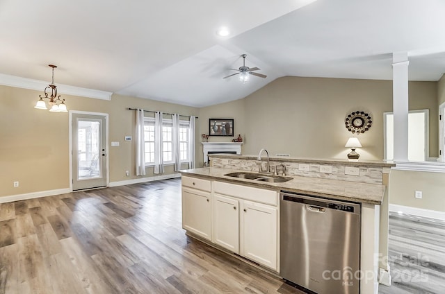 kitchen featuring sink, white cabinetry, light stone counters, decorative light fixtures, and stainless steel dishwasher