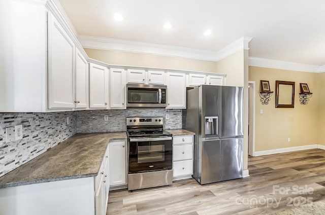 kitchen featuring crown molding, tasteful backsplash, appliances with stainless steel finishes, light hardwood / wood-style floors, and white cabinets