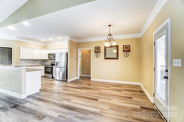 kitchen with stainless steel appliances, white cabinetry, crown molding, and decorative light fixtures