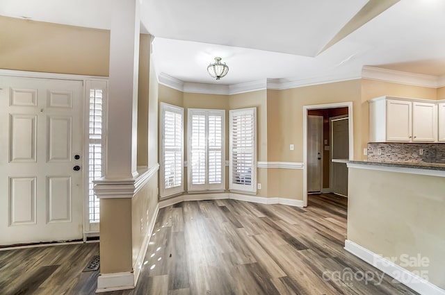 foyer entrance featuring ornamental molding and wood-type flooring