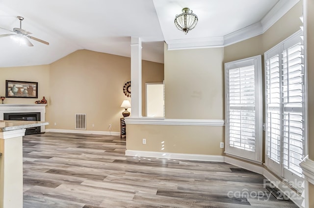 living room with ceiling fan, a healthy amount of sunlight, light hardwood / wood-style floors, and vaulted ceiling