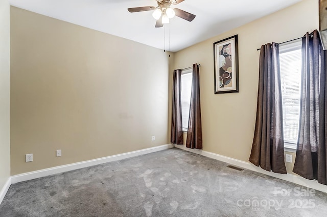 carpeted empty room featuring a wealth of natural light and ceiling fan