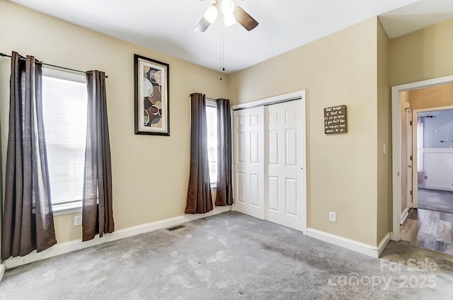 unfurnished bedroom with light colored carpet, a closet, and ceiling fan