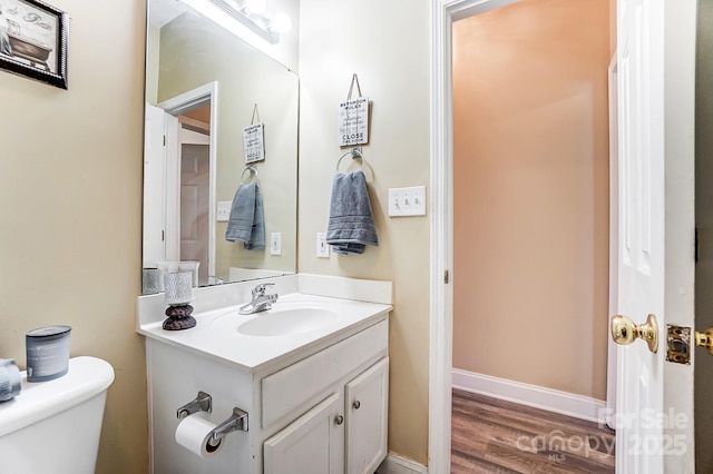 bathroom featuring vanity, hardwood / wood-style floors, and toilet