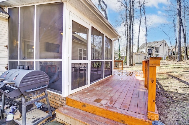 deck with grilling area and a sunroom