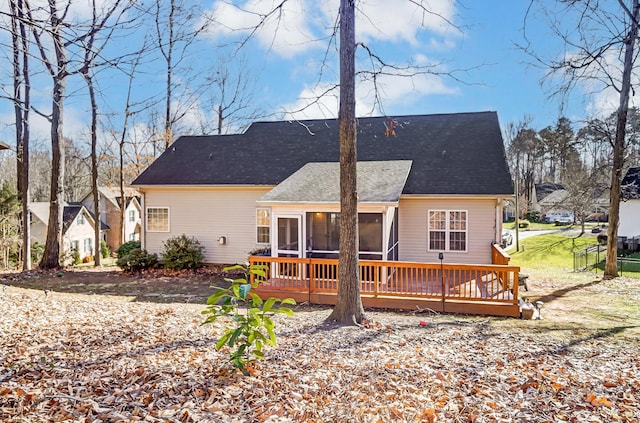 rear view of property featuring a wooden deck and a sunroom