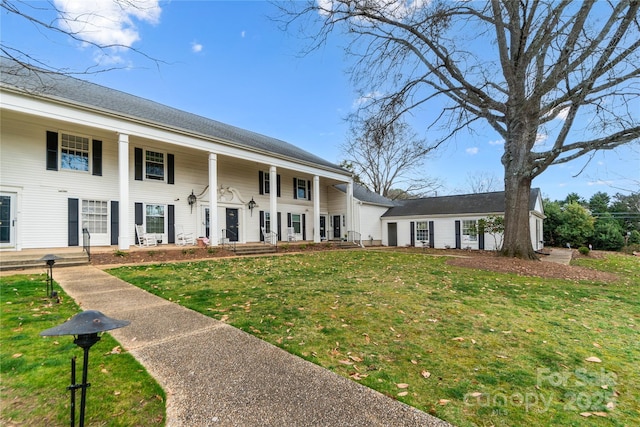 view of front of house featuring covered porch and a front lawn