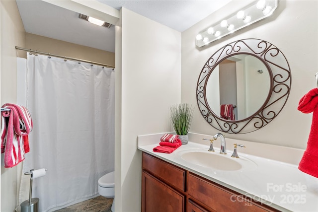 bathroom featuring a shower with shower curtain, vanity, and toilet