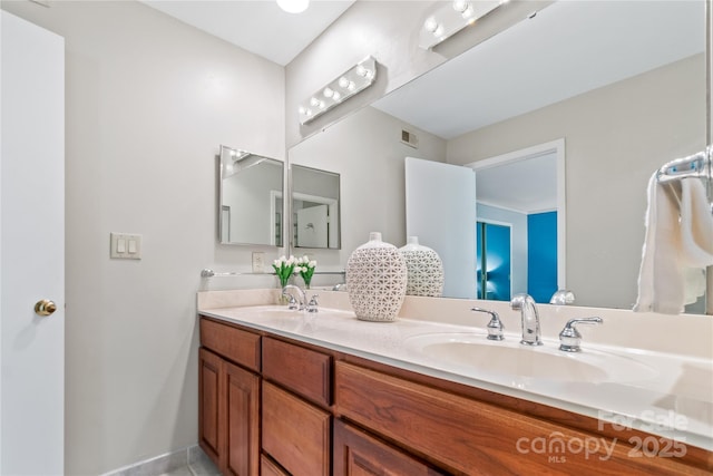 bathroom with double vanity, a sink, and visible vents