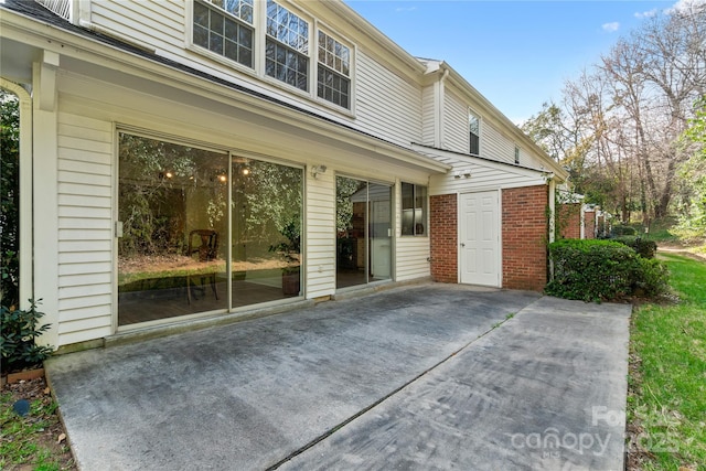 exterior space with a patio area and brick siding