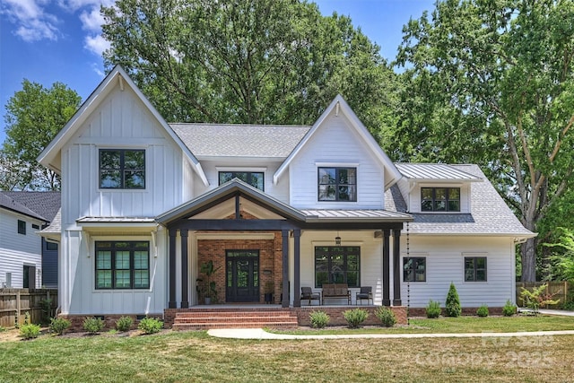 modern farmhouse style home featuring a porch and a front yard