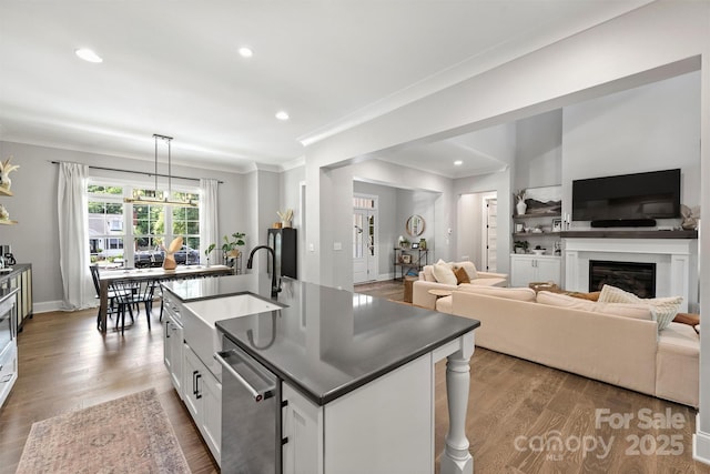 kitchen featuring pendant lighting, sink, white cabinetry, a kitchen island with sink, and stainless steel dishwasher