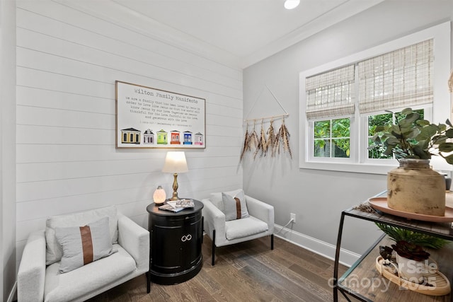 sitting room with ornamental molding and dark hardwood / wood-style floors