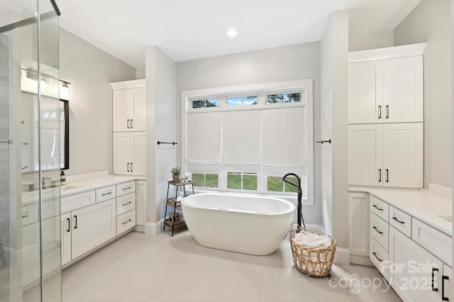 bathroom featuring vanity and independent shower and bath