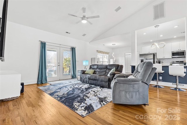 living room featuring french doors, ceiling fan, high vaulted ceiling, and light wood-type flooring