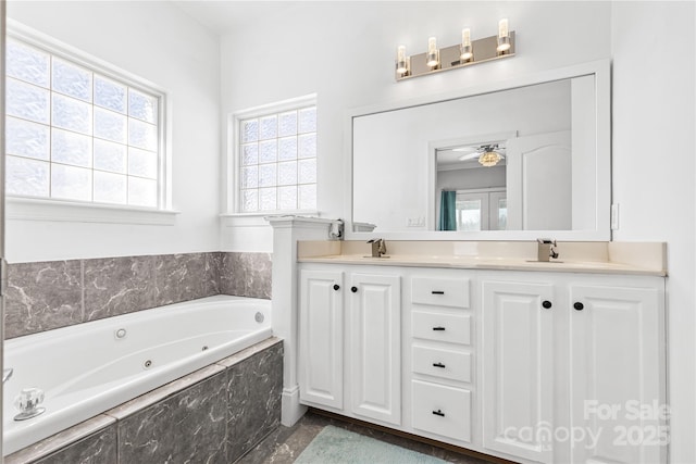 bathroom with a relaxing tiled tub, ceiling fan, and vanity