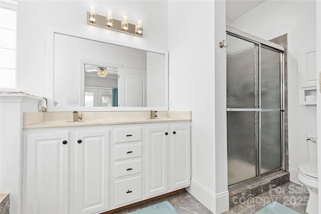 bathroom with a shower with door, vanity, and toilet