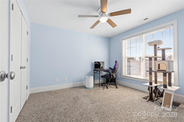 carpeted office space with ceiling fan