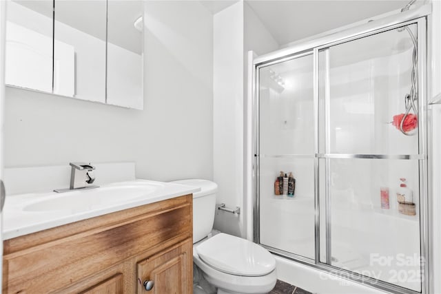 bathroom with vanity, a shower with shower door, and toilet