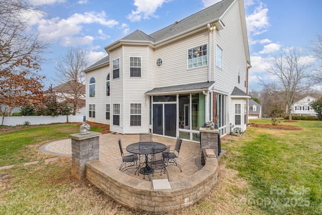 rear view of property with a yard, a patio area, and a sunroom