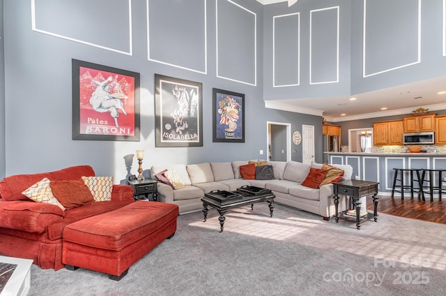 living room featuring a high ceiling, ornamental molding, and wood-type flooring