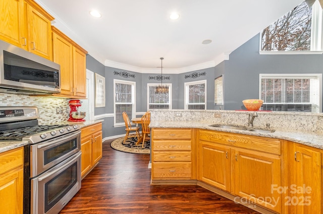 kitchen with sink, ornamental molding, appliances with stainless steel finishes, light stone countertops, and decorative backsplash