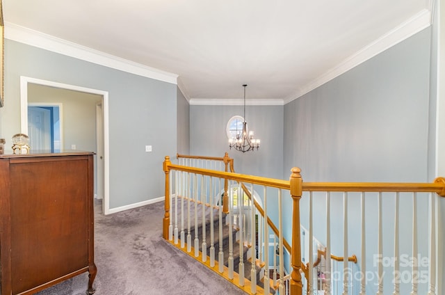 hall with carpet floors, ornamental molding, and a chandelier