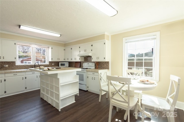 kitchen featuring white appliances, a center island, white cabinets, dark hardwood / wood-style flooring, and decorative backsplash