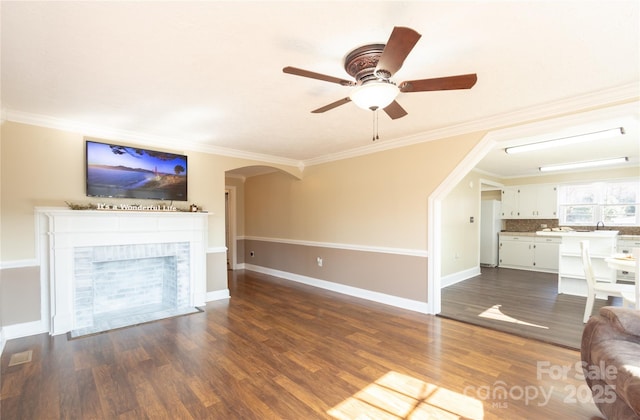 unfurnished living room featuring crown molding and dark wood-type flooring