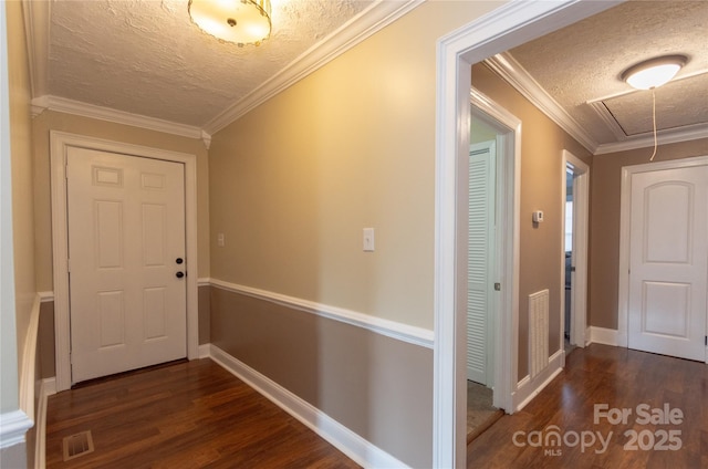 hall featuring ornamental molding, dark wood-type flooring, and a textured ceiling