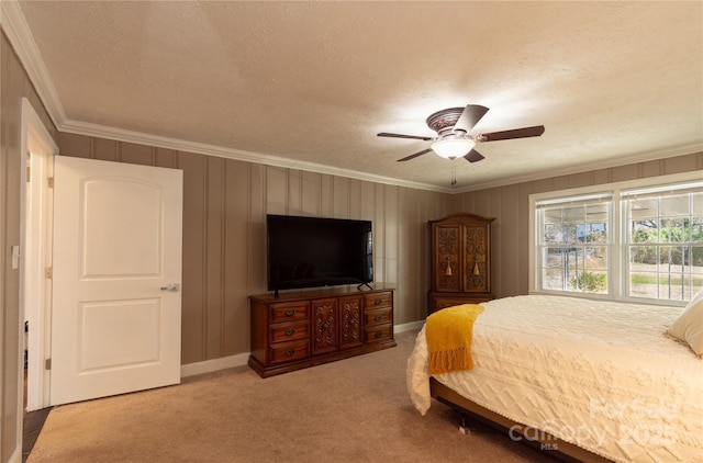 bedroom with ceiling fan, light colored carpet, ornamental molding, and a textured ceiling