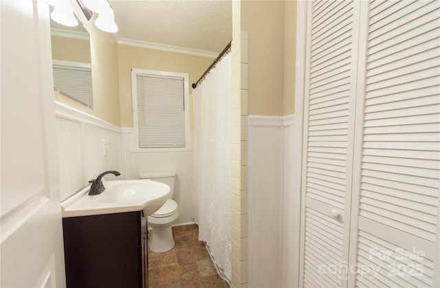 bathroom with vanity, a textured ceiling, crown molding, and toilet