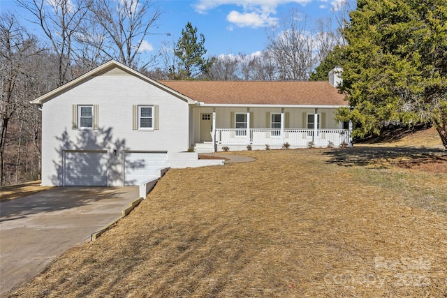 ranch-style house featuring a garage, a front lawn, and covered porch