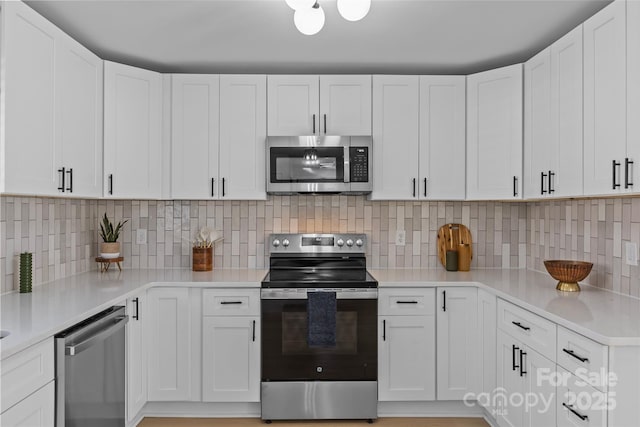 kitchen featuring tasteful backsplash, white cabinets, and appliances with stainless steel finishes