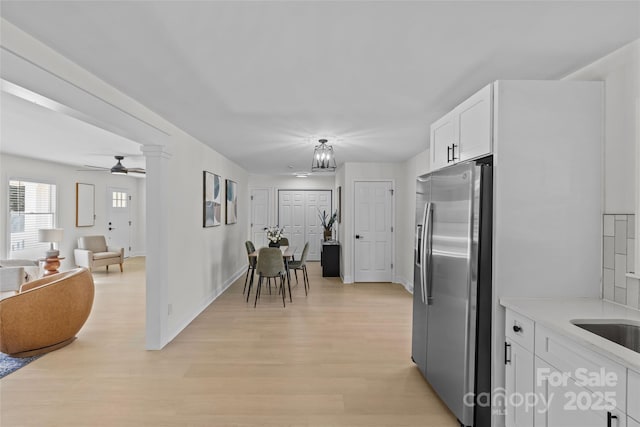 kitchen with stainless steel fridge with ice dispenser, light hardwood / wood-style flooring, white cabinets, and ceiling fan