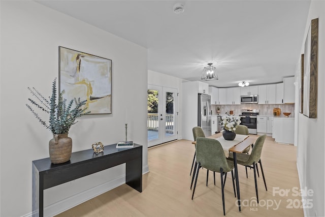 dining area with light hardwood / wood-style floors and french doors