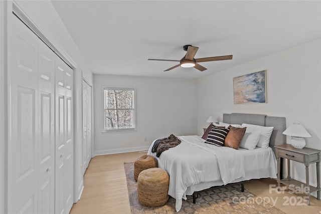 bedroom with multiple closets, ceiling fan, and light wood-type flooring