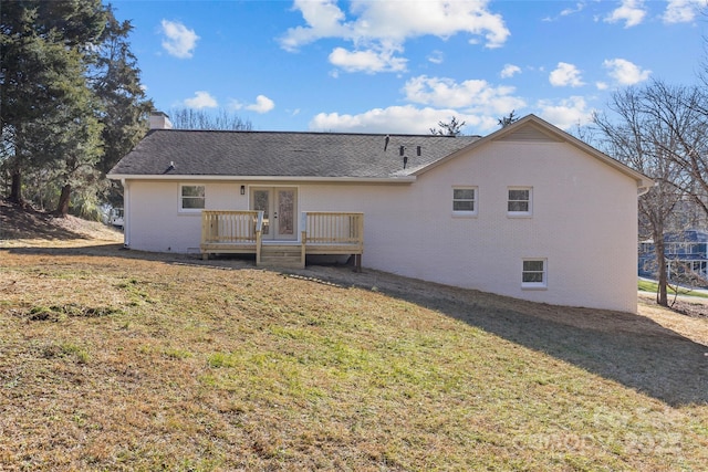 back of property featuring a yard, a deck, and french doors