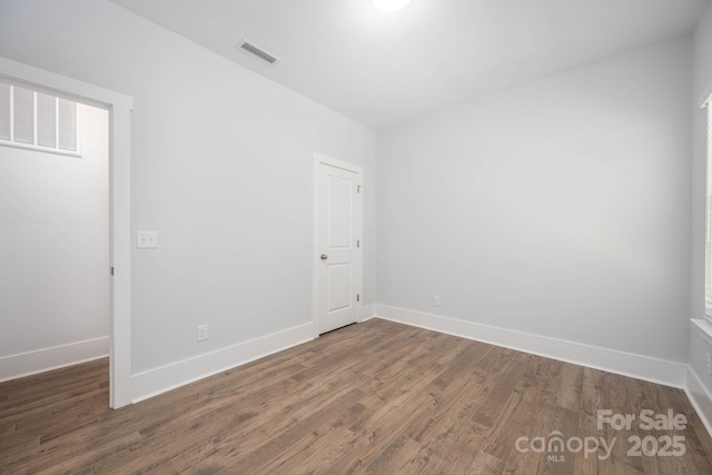 unfurnished room with dark wood-type flooring