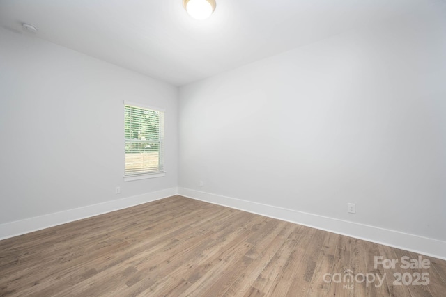 unfurnished room with hardwood / wood-style flooring