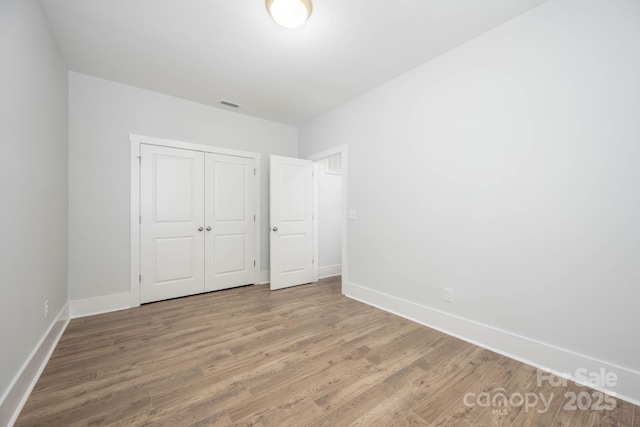 unfurnished bedroom featuring hardwood / wood-style flooring and a closet