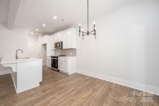 kitchen with a breakfast bar, tasteful backsplash, sink, white cabinets, and stainless steel appliances