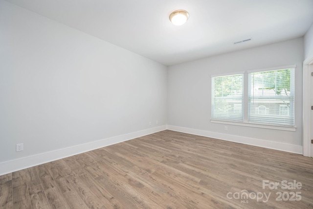 unfurnished room with hardwood / wood-style flooring