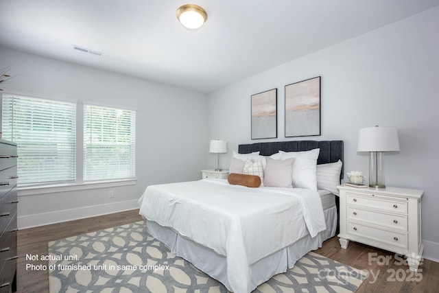 bedroom with dark hardwood / wood-style floors