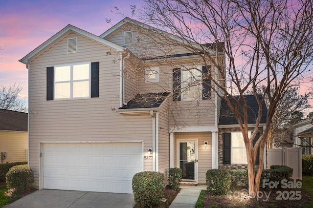 traditional-style home featuring fence, a garage, and driveway