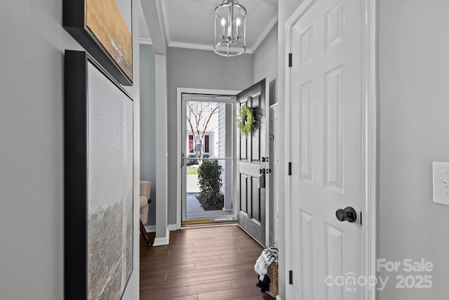 entryway featuring ornamental molding, baseboards, an inviting chandelier, and dark wood-style flooring