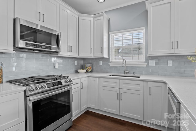 kitchen with a sink, light countertops, white cabinets, stainless steel appliances, and dark wood-style flooring