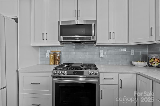 kitchen featuring stainless steel appliances, backsplash, and white cabinetry